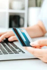 Woman inputting credit card details onto computer-1637322013444